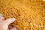 Orange wool rug styled in a living room