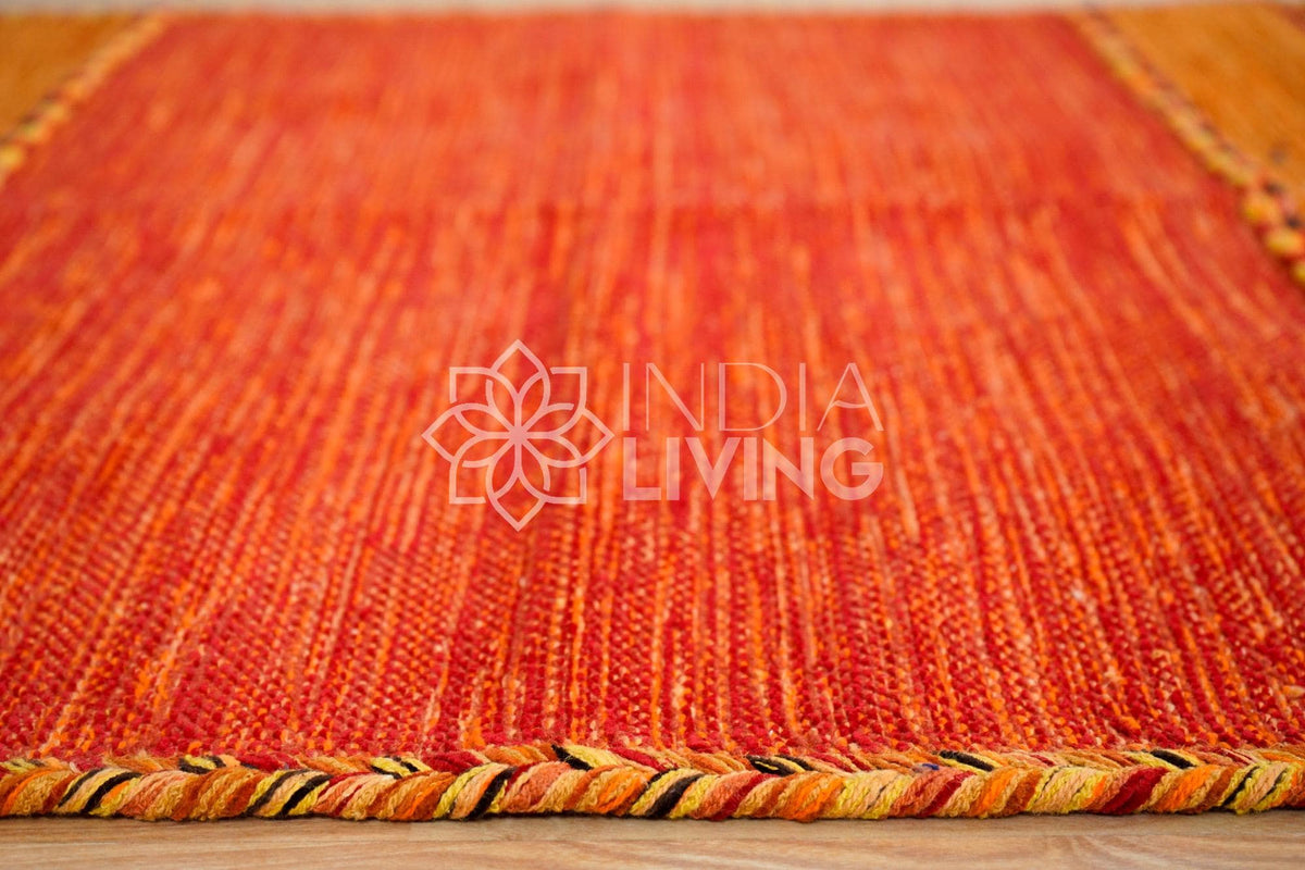 Overhead view of orange kilim rug