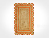 Orange braided jute rug styled in an entryway