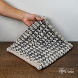 Corner detail of handwoven grey wool rug