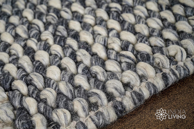 Grey wool rug styled in a living room