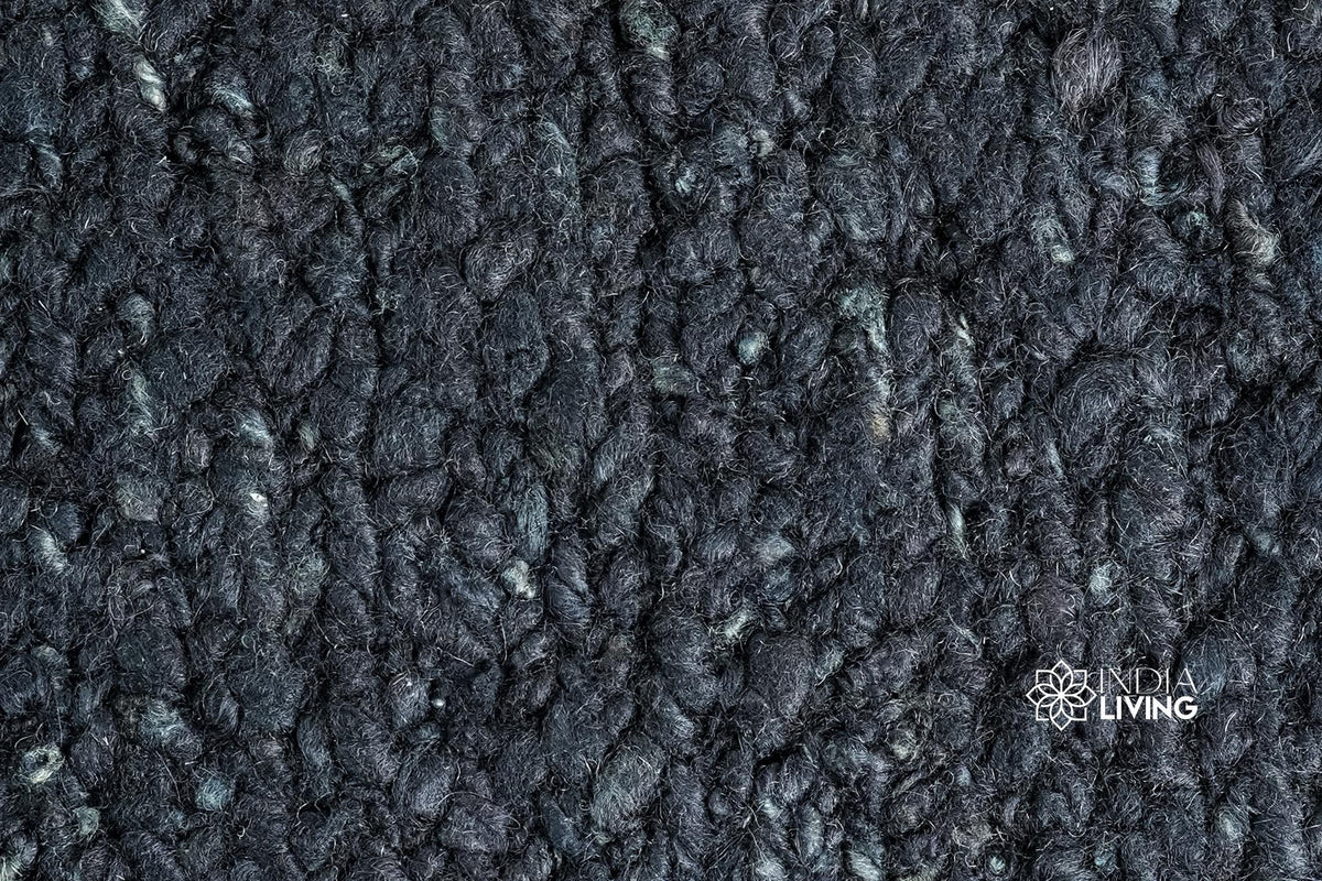 Black wool rug under a bed lifestyle shot
