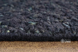 Textured pile close-up of solid black wool rug