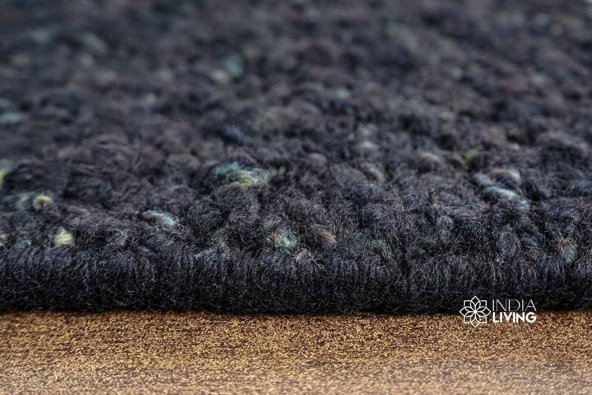Textured pile close-up of solid black wool rug