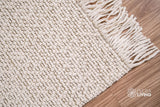 Ivory basket weave wool rug rolled showing thickness