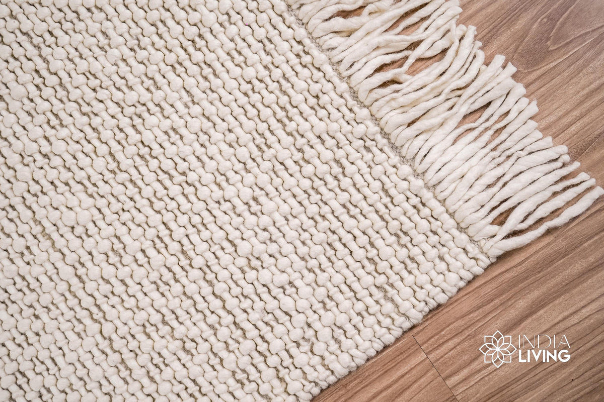 Ivory basket weave wool rug rolled showing thickness