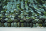 Moss green felted wool rug in a living room styling