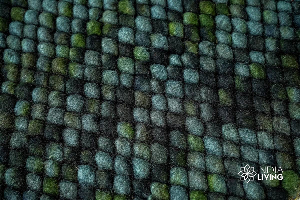 Moss green wool rug shown with pet nearby