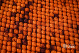 Corner detail of handwoven rust orange wool rug