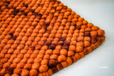 Rust orange felted wool rug, flat lay view