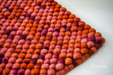 Terracotta red wool rug corner detail showing reversible edge