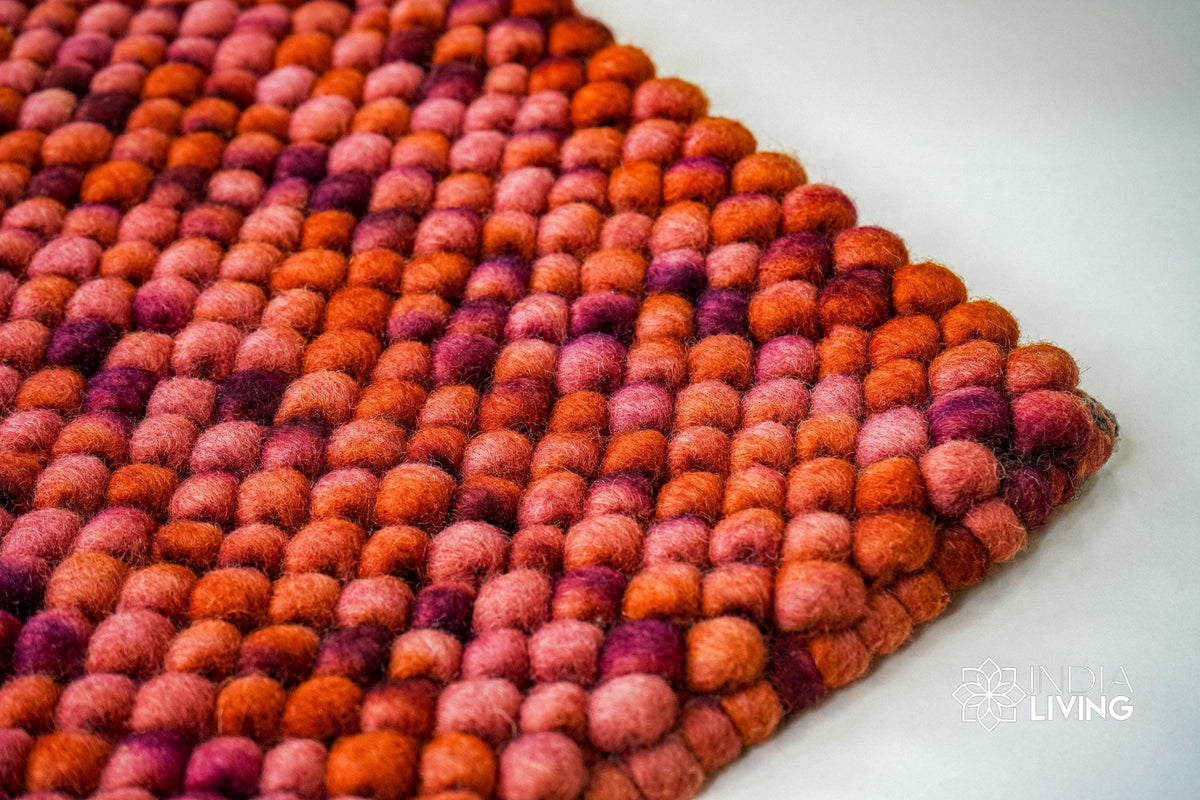 Terracotta red wool rug corner detail showing reversible edge