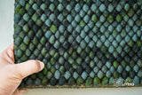 Corner detail of handwoven moss green wool rug