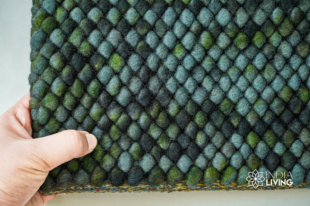 Corner detail of handwoven moss green wool rug