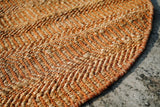 Orange jute round rug styled in a living room setting