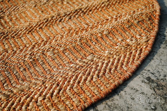 Orange jute round rug styled in a living room setting