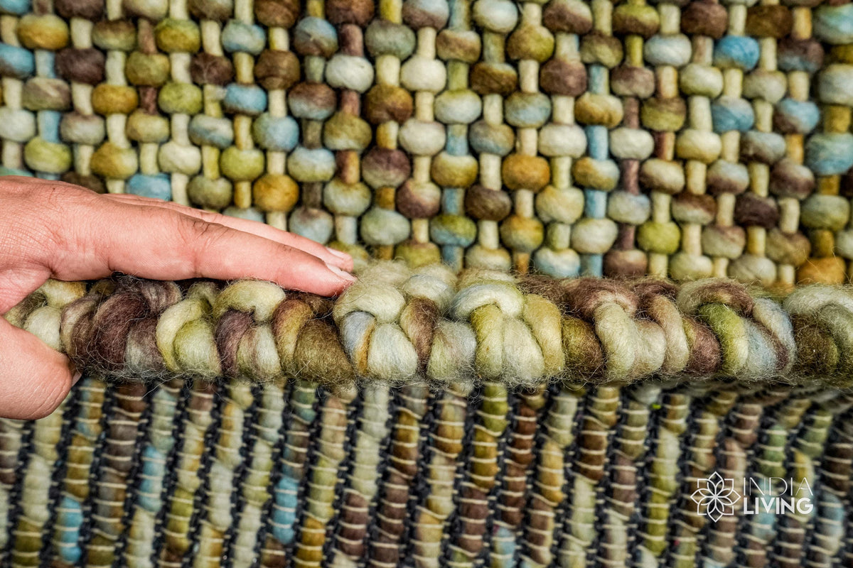 Green wool rug styled with furniture in room