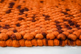 Rust orange wool rug shown with pet nearby