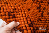 Rust orange felted rug in a bedroom setting
