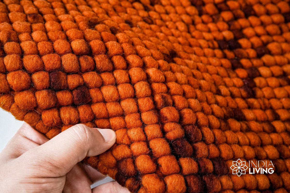 Rust orange felted rug in a bedroom setting