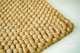 Tan beige wool rug in a bedroom decor setting