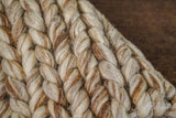 Beige brown braided wool rug styled in a living room