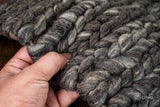 Close-up of charcoal grey wool rug braided texture