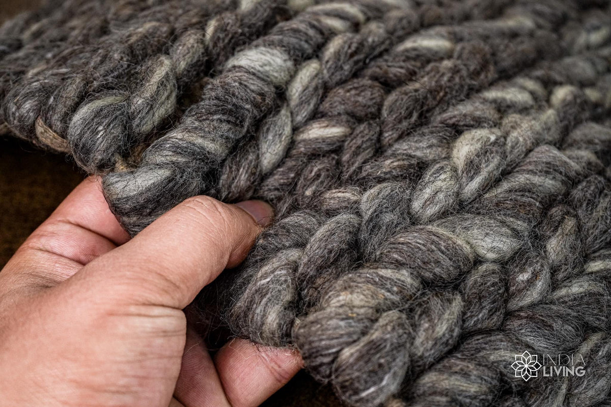 Close-up of charcoal grey wool rug braided texture