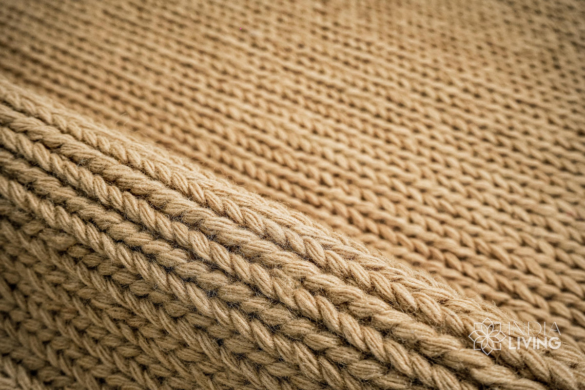 Tan beige wool rug in a bedroom setting