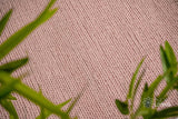 Light pink wool rug styled in a living room