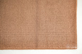 Tan brown wool rug in a bedroom setting