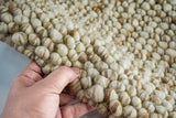 Natural beige wool rug in a cozy bedroom setting