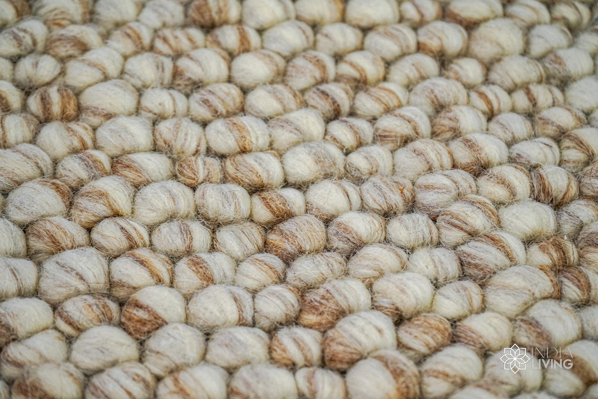 Beige pebble wool rug placed under a coffee table