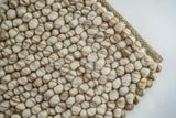 Beige pebble wool rug styled in a Scandinavian living room