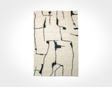 Ivory wool rug with black abstract berber pattern, flat lay