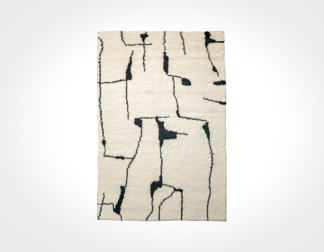 Ivory wool rug with black abstract berber pattern, flat lay
