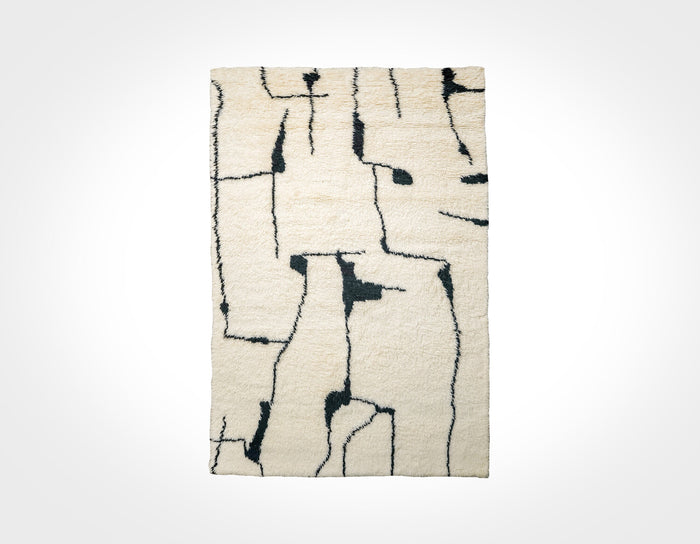 Ivory wool rug with black abstract berber pattern, flat lay