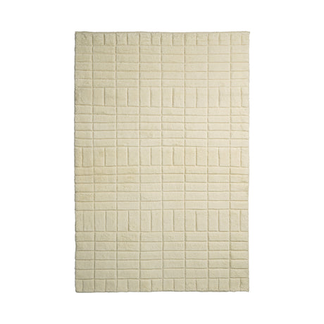 May include: A white, rectangular rug with a textured, grid pattern. The rug is made of a soft, plush material and has a subtle sheen.