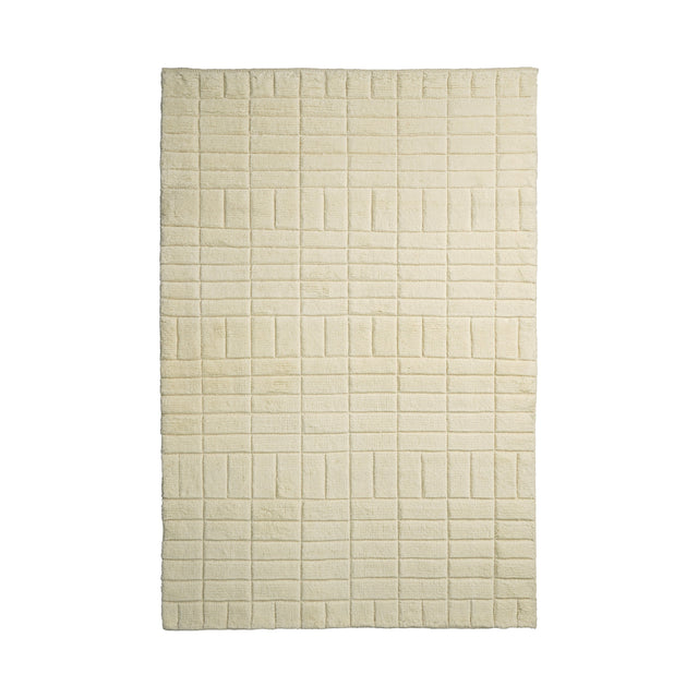 Minimalist ivory wool rug with subtle grid texture, flat view