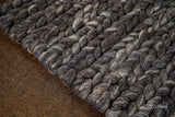 Charcoal grey wool rug in a modern bedroom setting