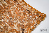 Corner detail of rust brown textured wool rug