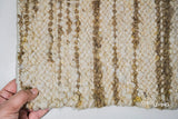 Corner detail of ivory beige striped wool rug