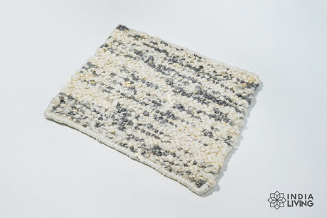 May include: A white and gray area rug with a textured, woven design. The rug is rectangular and has a fringed edge.