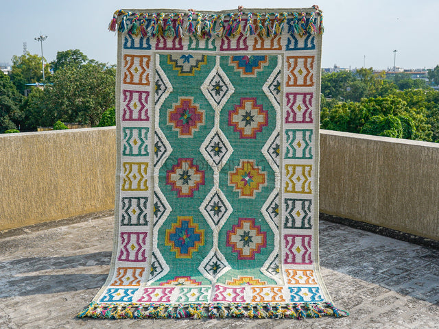 Green Moroccan rug with colourful geometric pattern and fringe