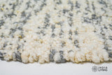 Corner detail of ivory grey textured wool rug