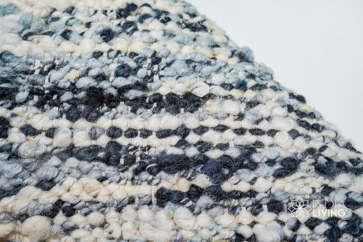 Corner detail of ivory blue textured wool rug
