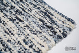 Full view of ivory blue textured wool rug on floor