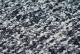 Full view of ivory black textured wool rug on floor