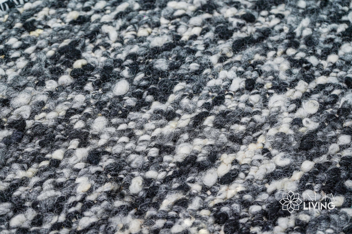 Full view of ivory black textured wool rug on floor