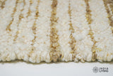 Full view of ivory beige striped wool rug on floor